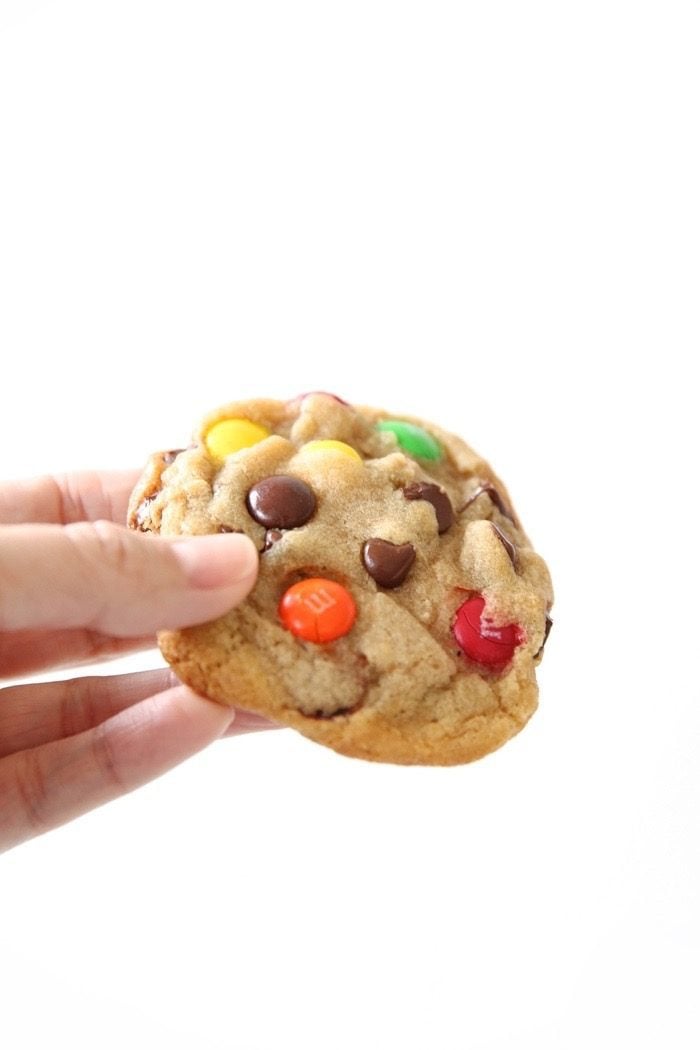 M&M cookies being held in a person\'s hand. 