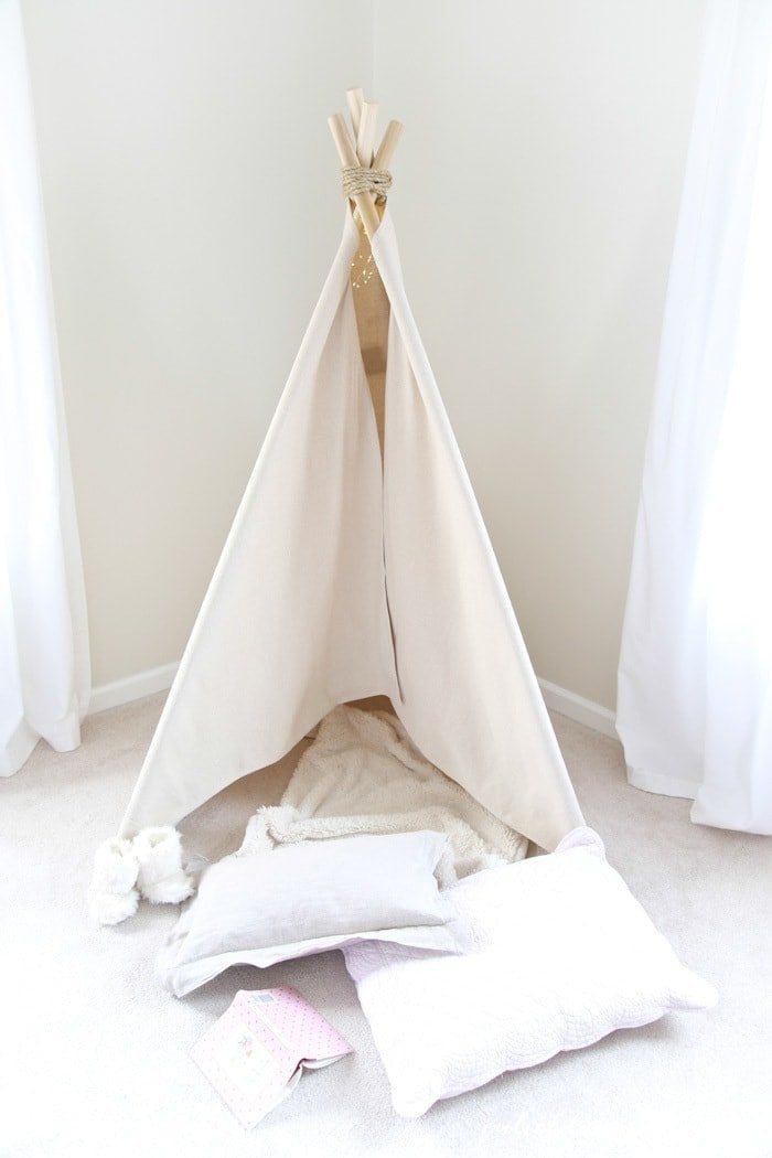 A teepee that is put together with pillows and blankets inside