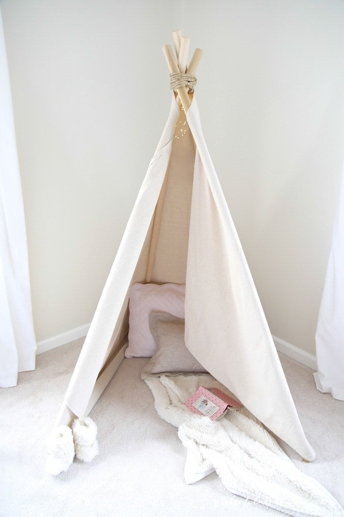 A teepee that is put together with pillows and blankets inside