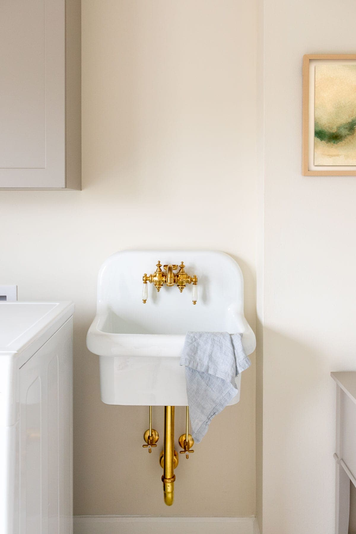 wall mount utility sink with brass pipes and faucet