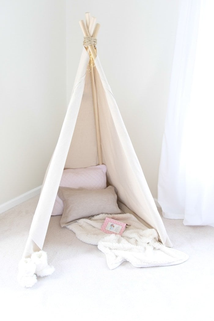 A teepee that is put together with pillows and blankets inside