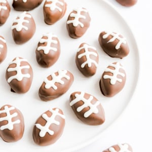 Peanut butter truffles shaped like footballs on a plate.