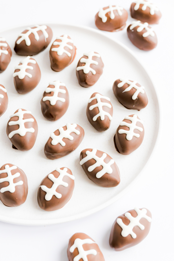 Peanut butter truffles shaped like footballs on a plate.