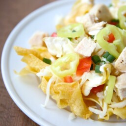 Incredible Italian nachos recipe with asiago cream sauce on a bed of pasta chips!