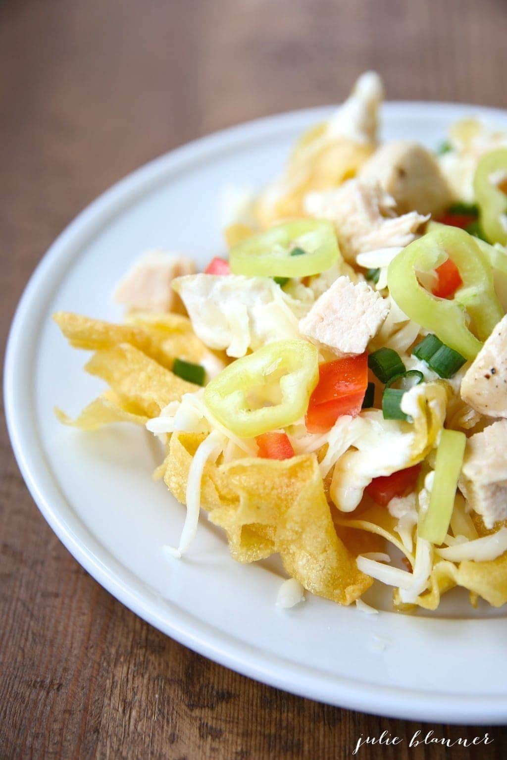 Italian nachos served on a white plate with toppings