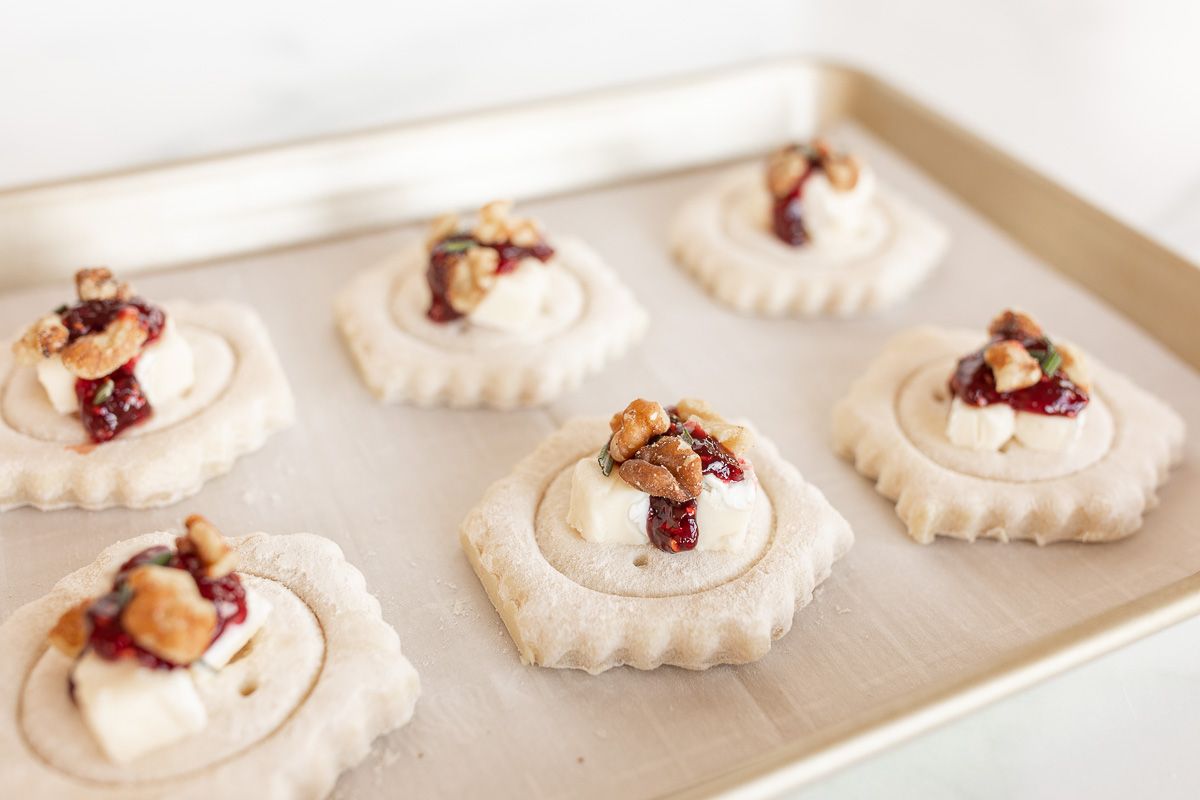 Brie bites in puff pastry on a baking sheet before baking