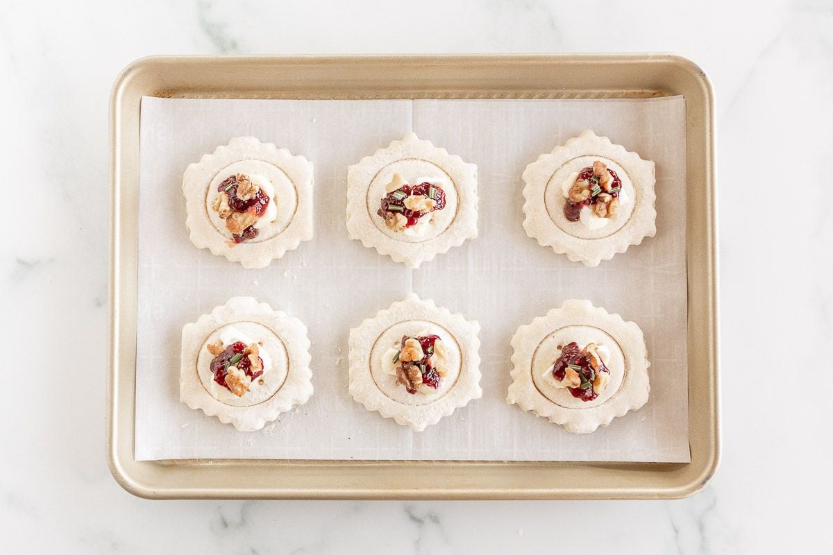 Brie bites in puff pastry on a baking sheet before baking