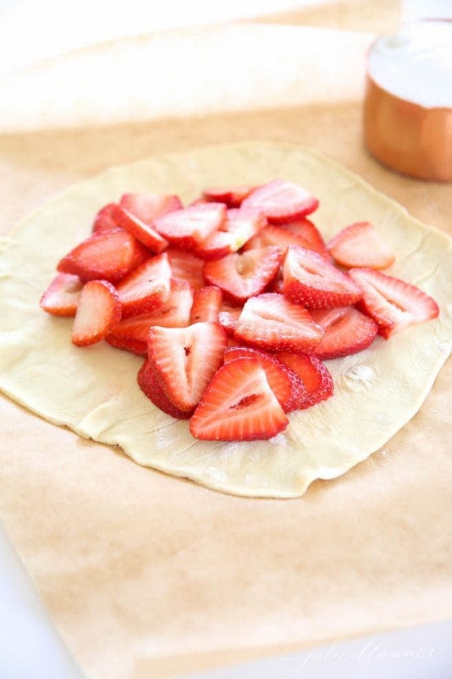 Sliced strawberries on the puff pastry sheet