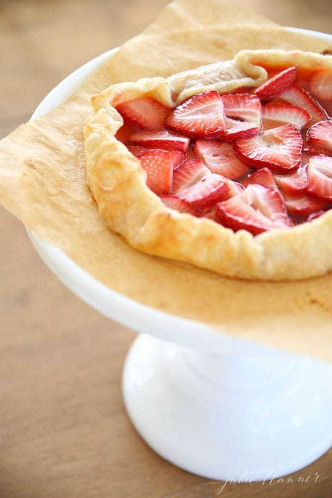 The baked strawberry tart on a cake stand