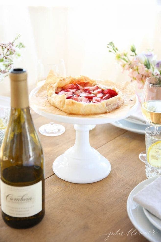 The quick strawberry tart served on a white cake stand