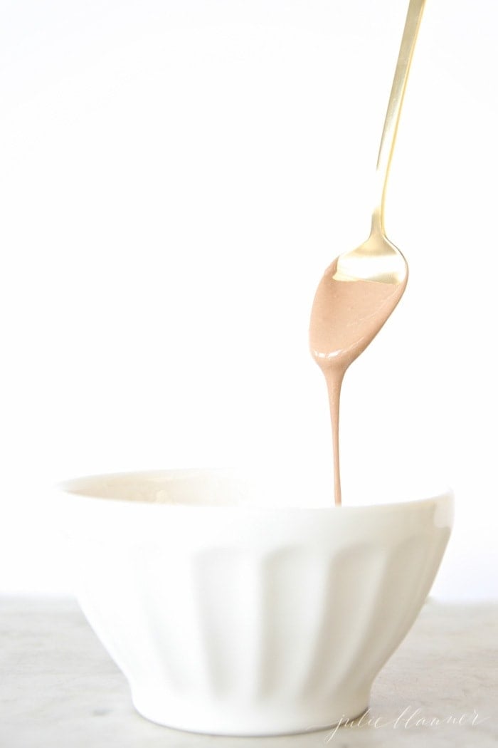 Close up of the chocolate sauce dripping off of a gold spoon