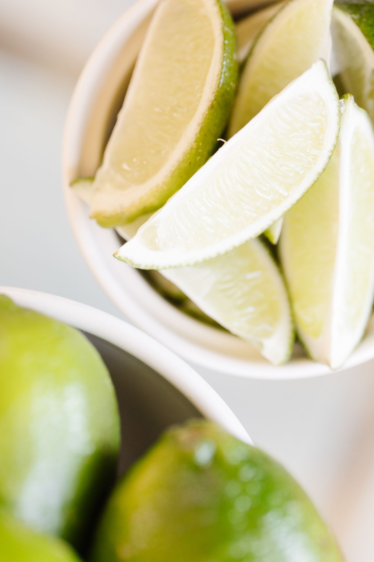A white bowl of sliced limes