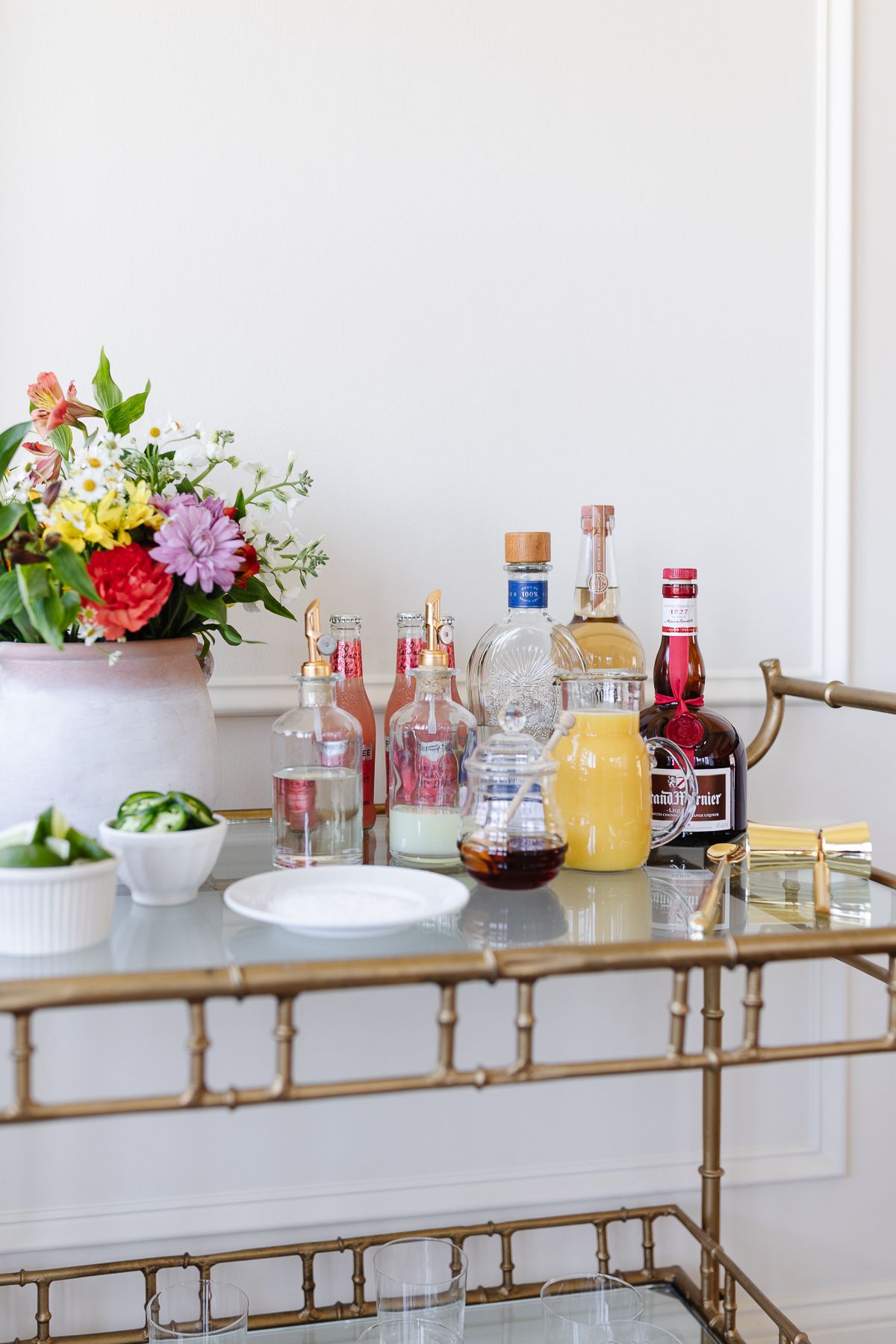 Ingredients for a margarita bar set up on a gold cart