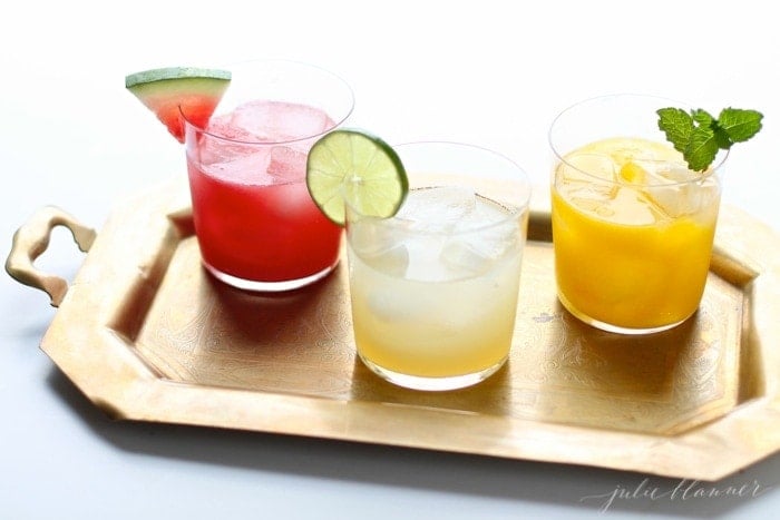 watermelon margarita on a tray with a skinny margarita and mango margarita