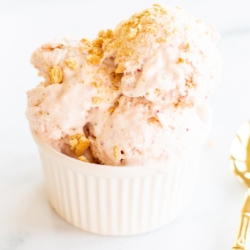 Strawberry cheesecake ice cream in a white bowl.