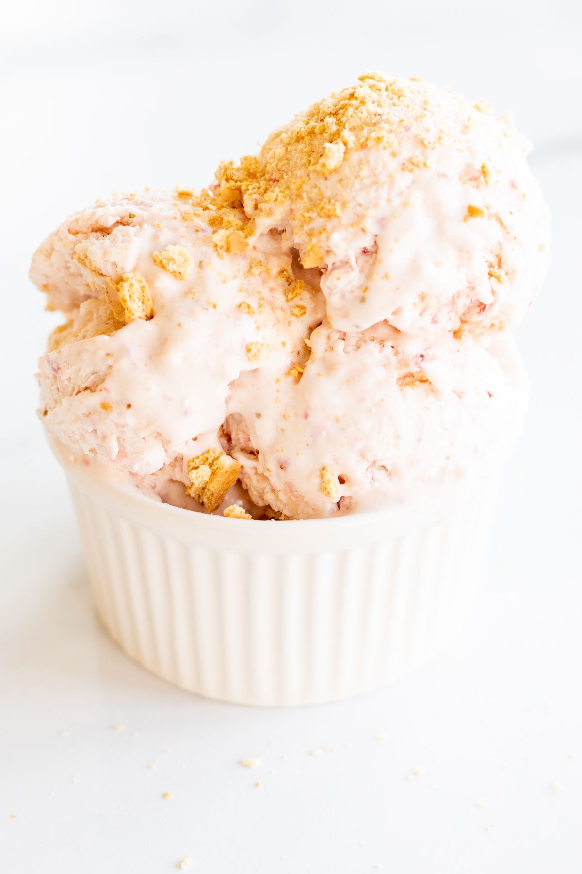 Strawberry cheesecake ice cream in a white bowl.