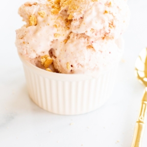 Strawberry cheesecake ice cream in a white bowl.