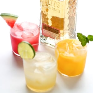 A variety of margaritas on a white surface, with a watermelon margarita on the left.