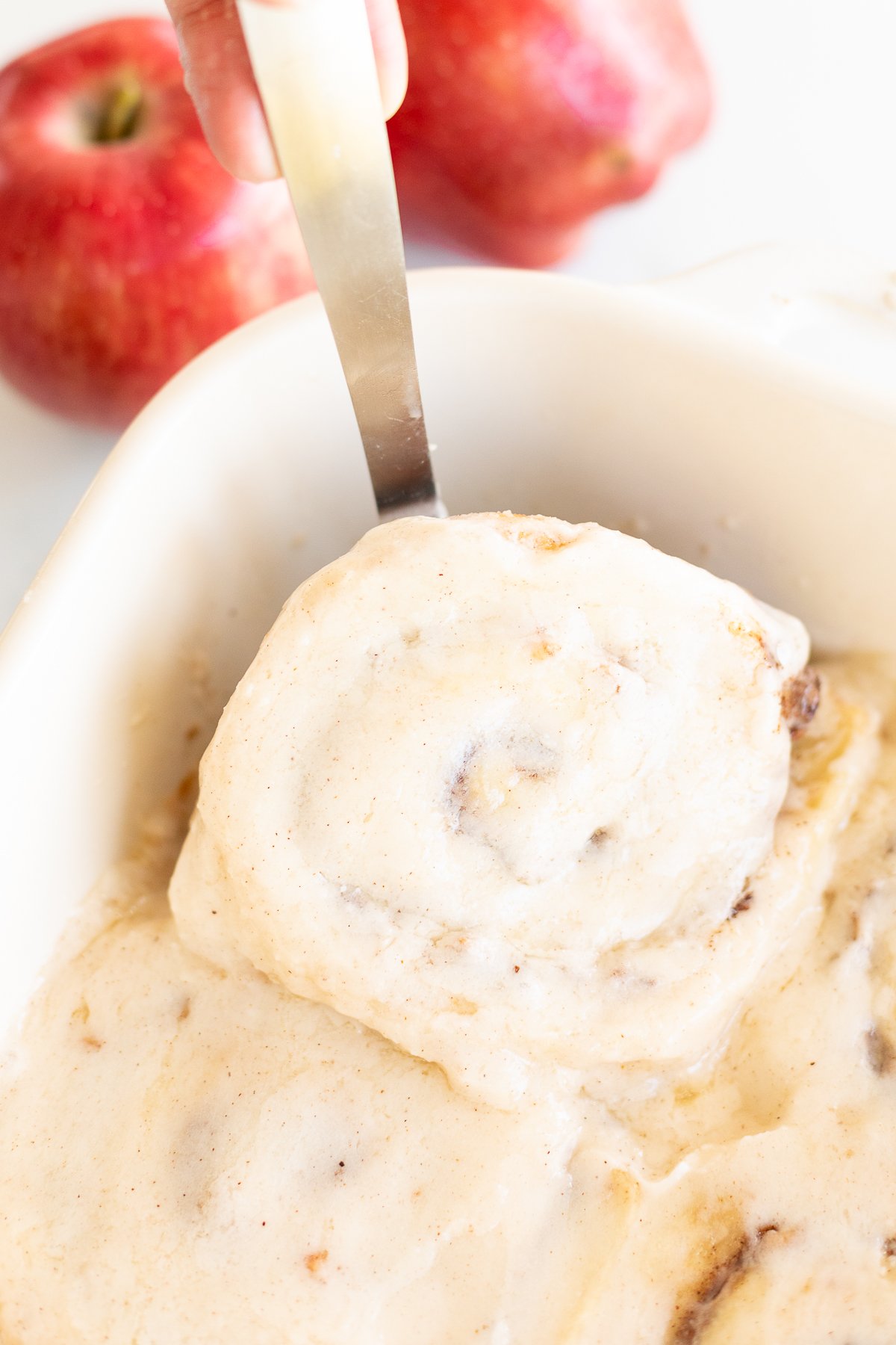 Delicious apple cinnamon rolls baked to perfection in a white baking dish.