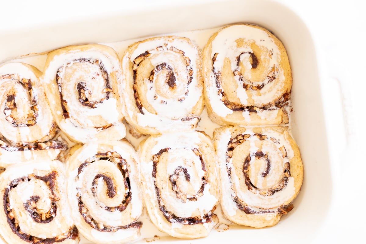 Apple cinnamon rolls in a white baking dish.