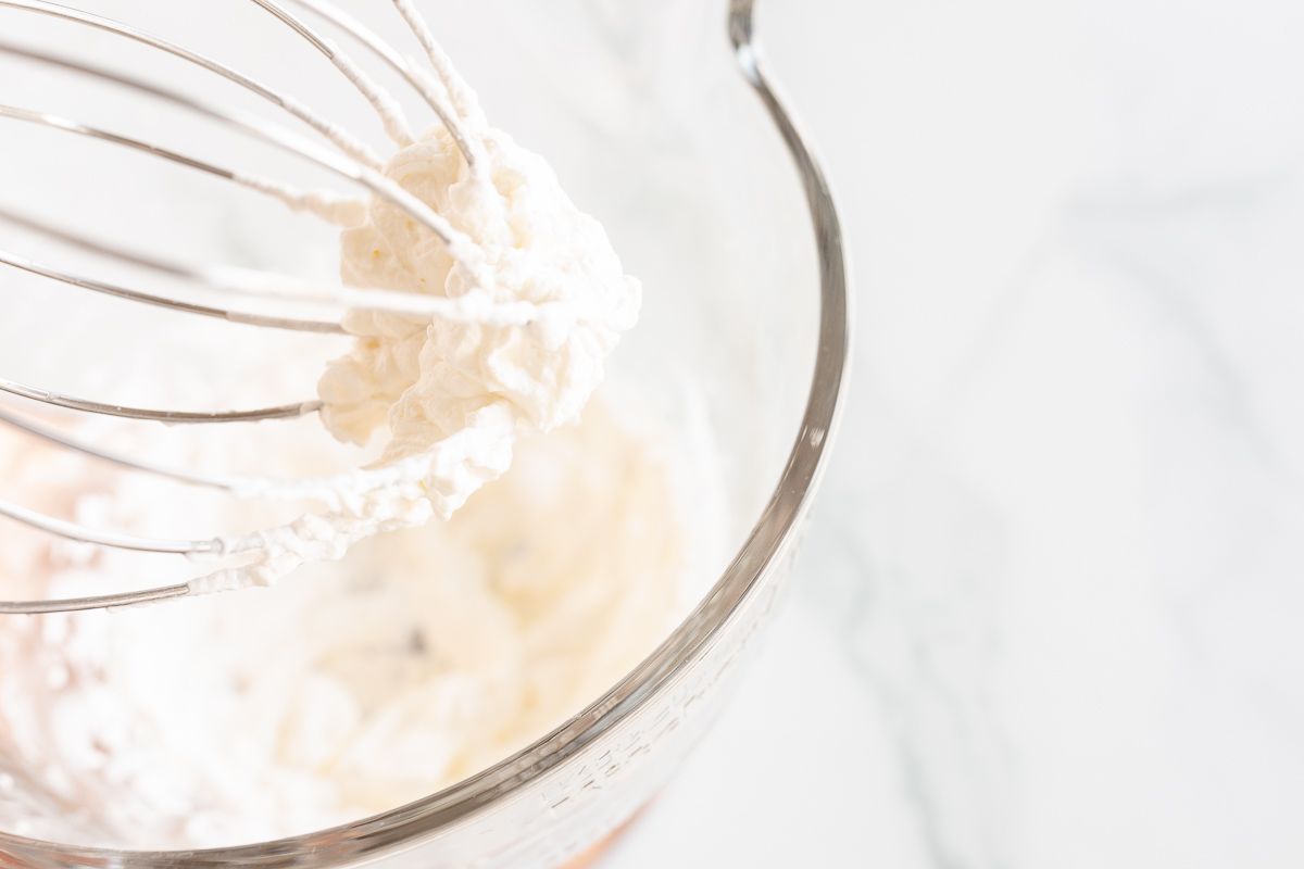 A glass stand mixer bowl full of mascarpone cream.