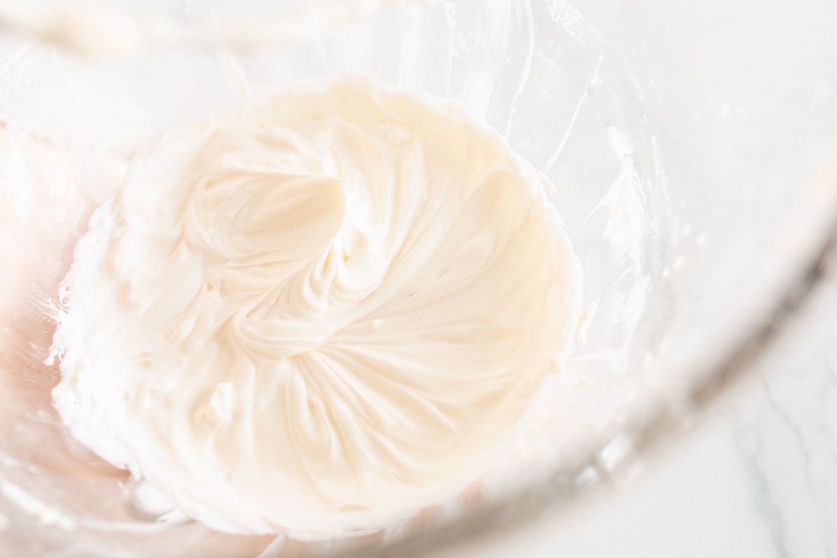 A glass stand mixer bowl full of mascarpone cream.