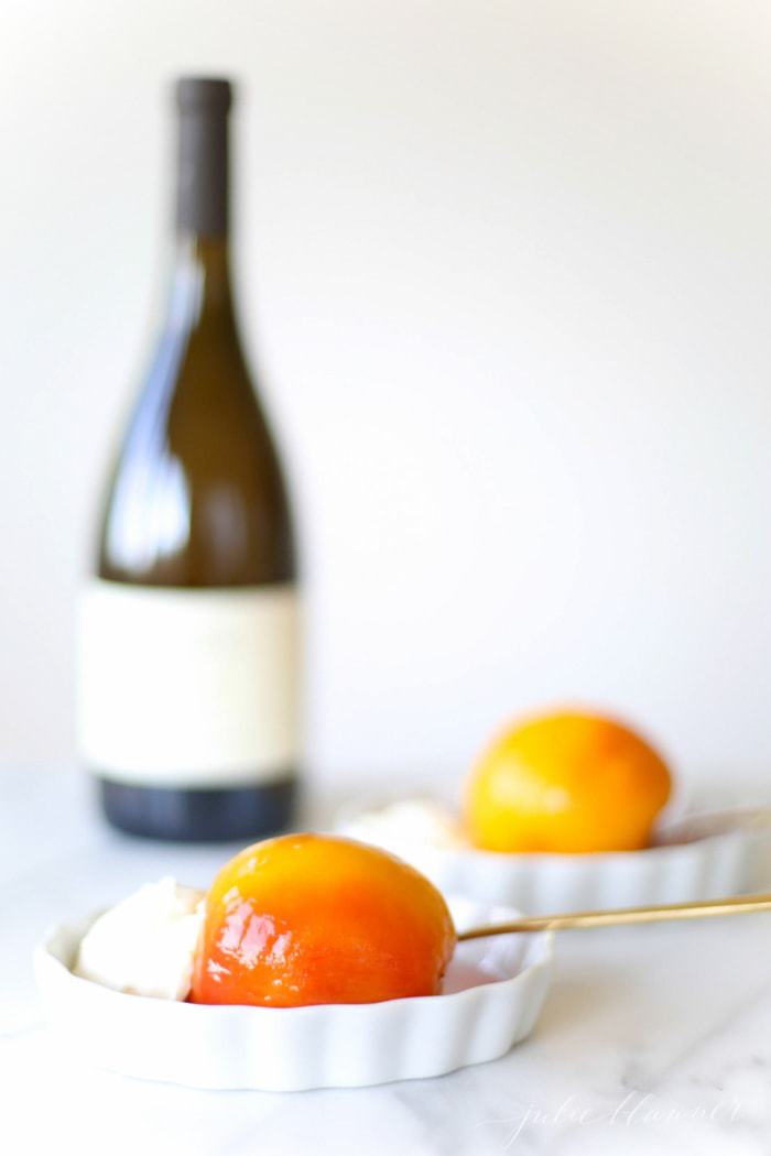 Poached peaches with mascarpone cream by wine bottle