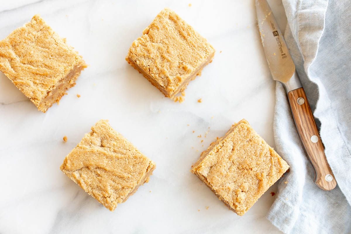 Peanut butter brownies cut into squares and spread out on a marble surface