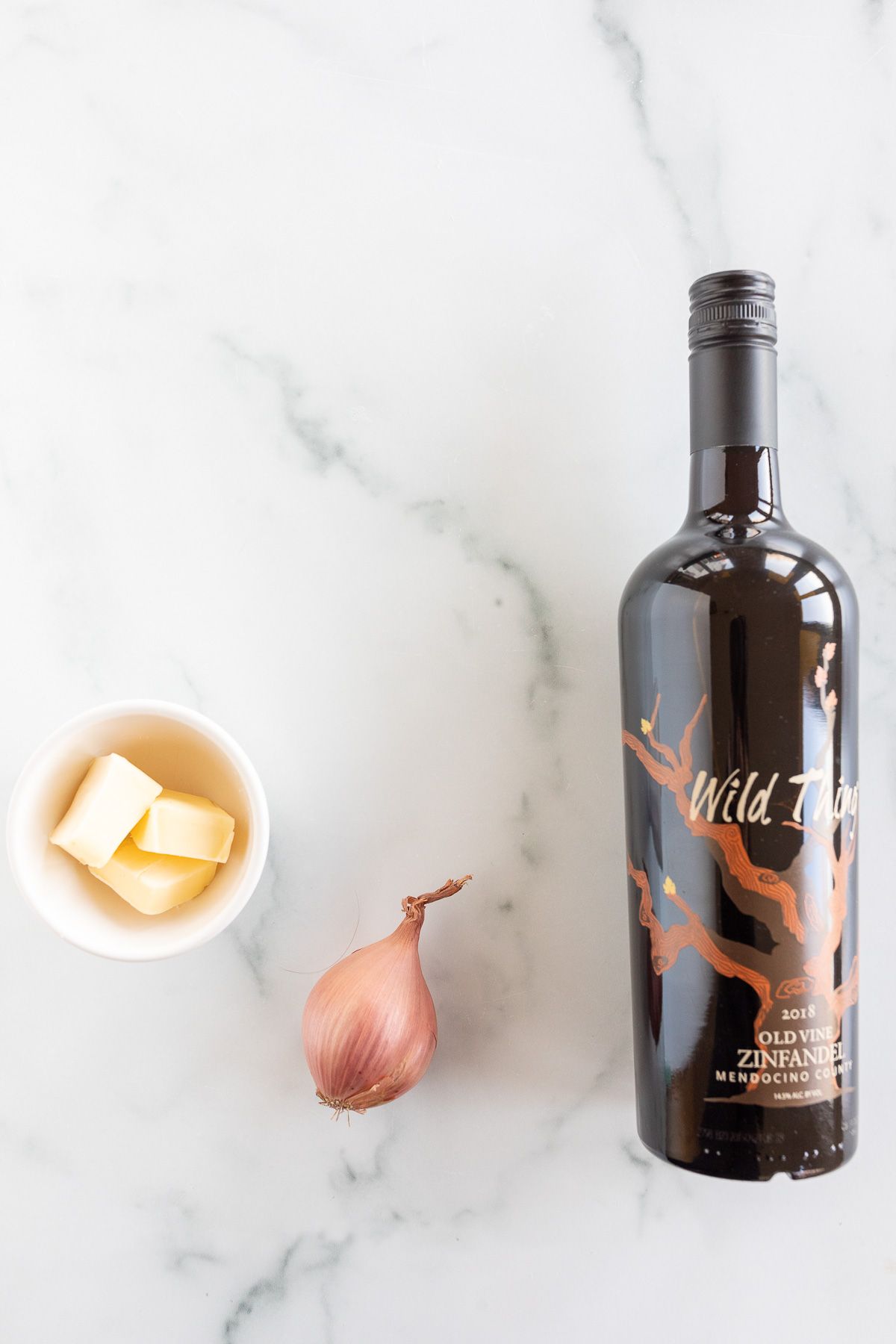 ingredients for red wine sauce for steak laid out on a marble surface