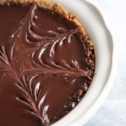 pretzel crust pie with chocolate filling in white baking dish