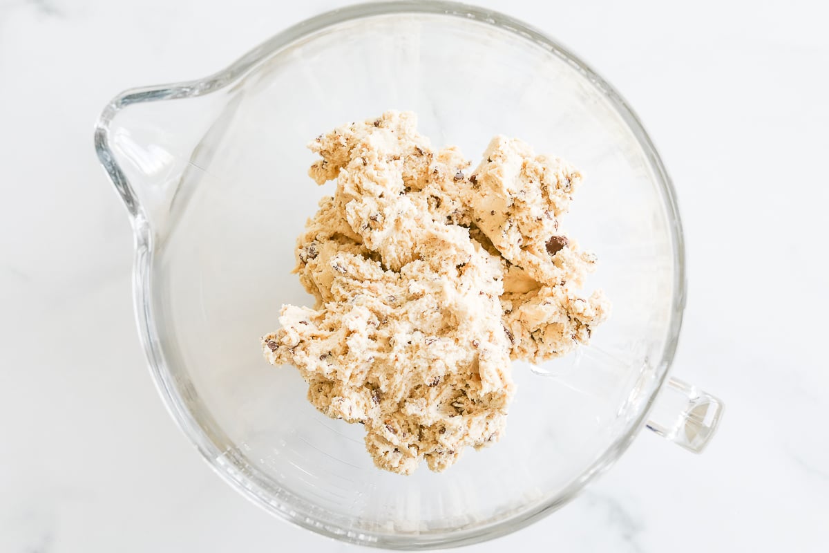 A glass bowl filled with a mixture of flour and oats, ready to be transformed into delicious toffee cookies.