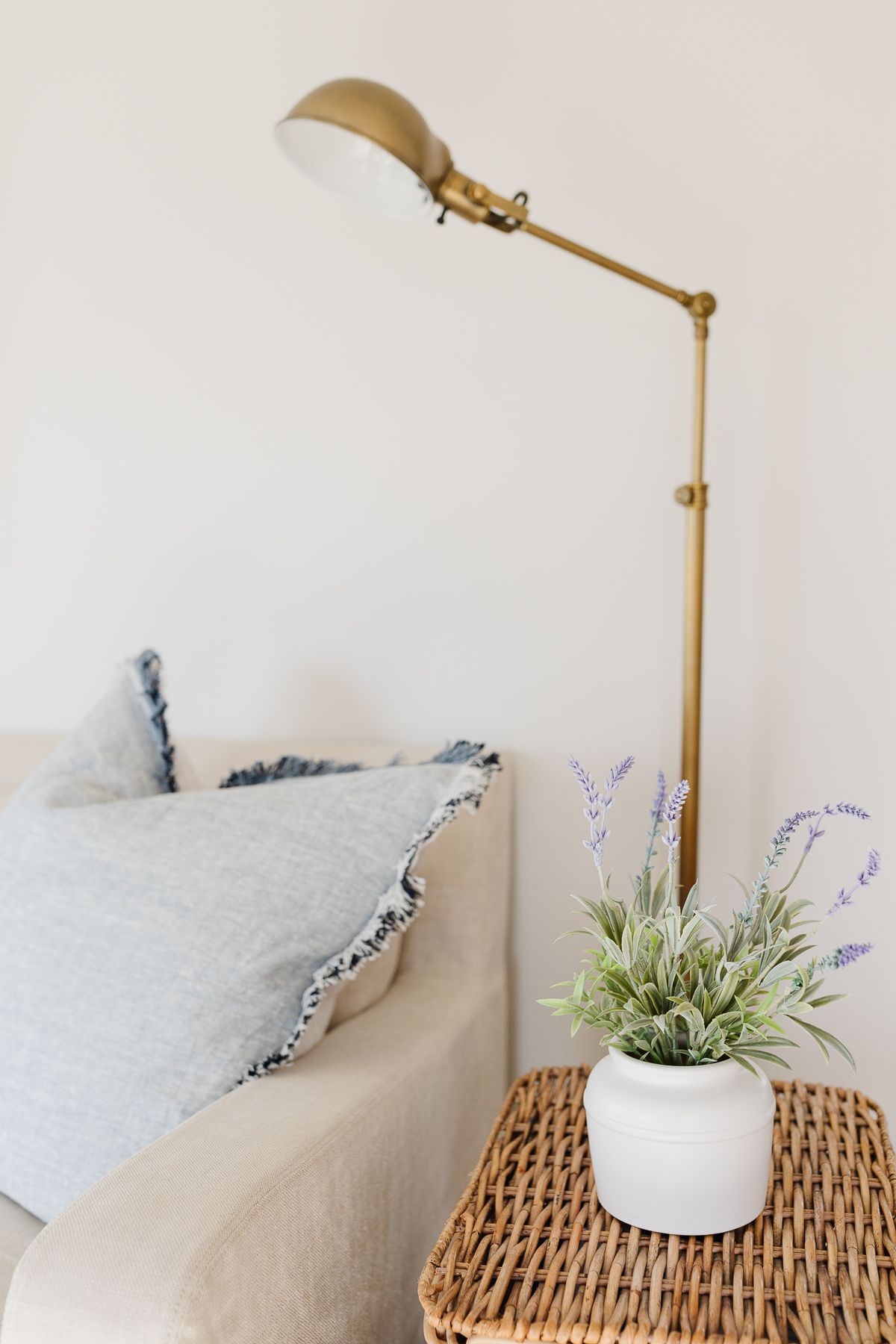 A restoration hardware linen sofa with stacked baskets as side tables 