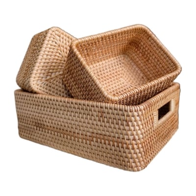 Three wicker storage baskets on a white background in a linen closet.
