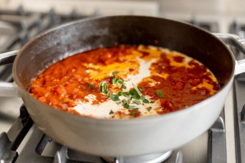 Vodka sauce simmering in a gray pot on a stove.