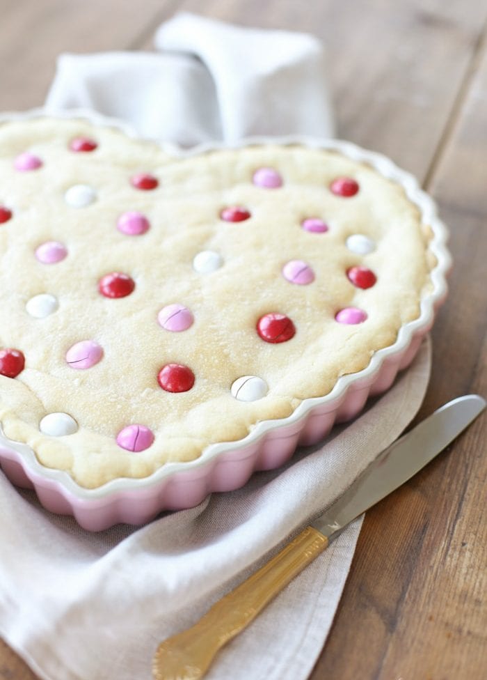 A sugar cookie cake in a heart shaped dish