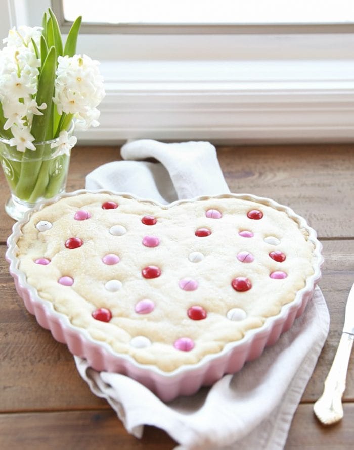 A heart shaped sugar cookie cake on a kitchen work surface