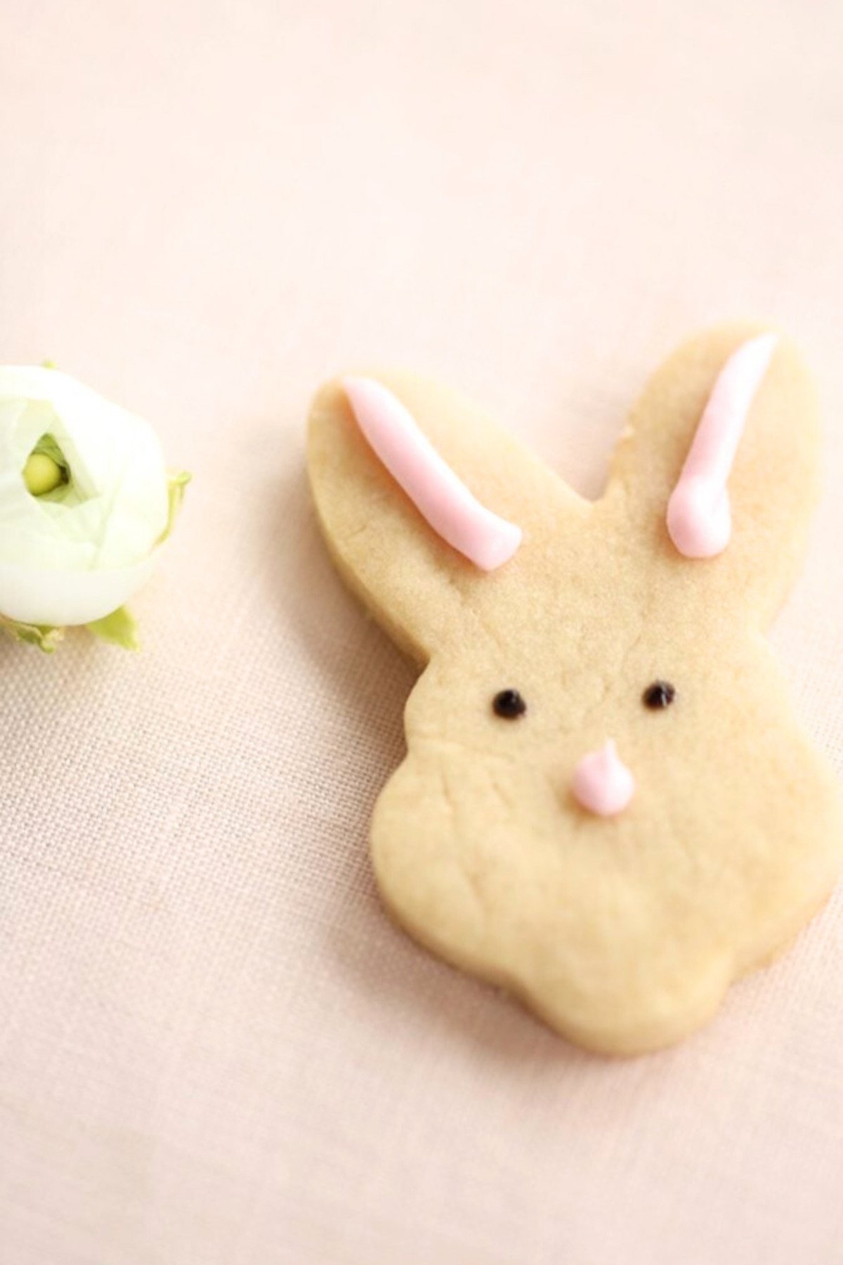 An Easter shortbread cookie in the shape of a bunny face.