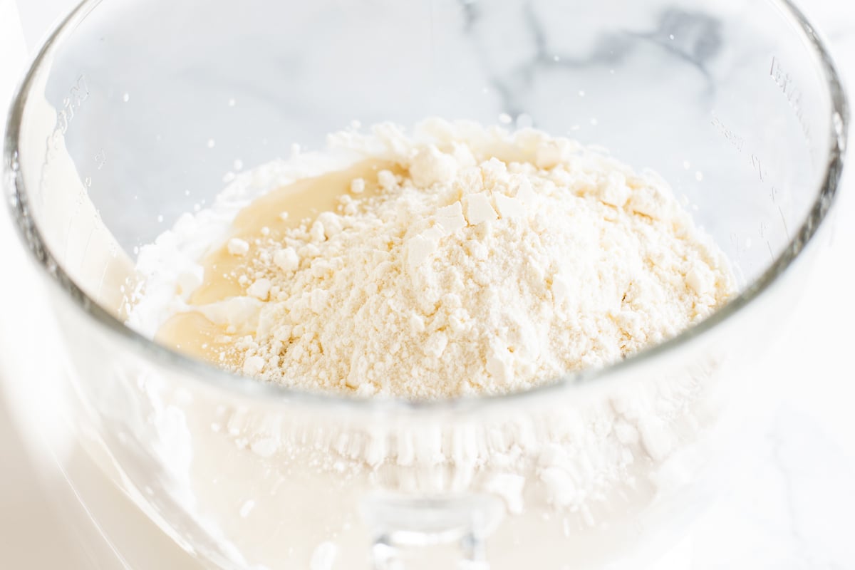 Cake batter ice cream ingredients in a glass bowl of a stand mixer.