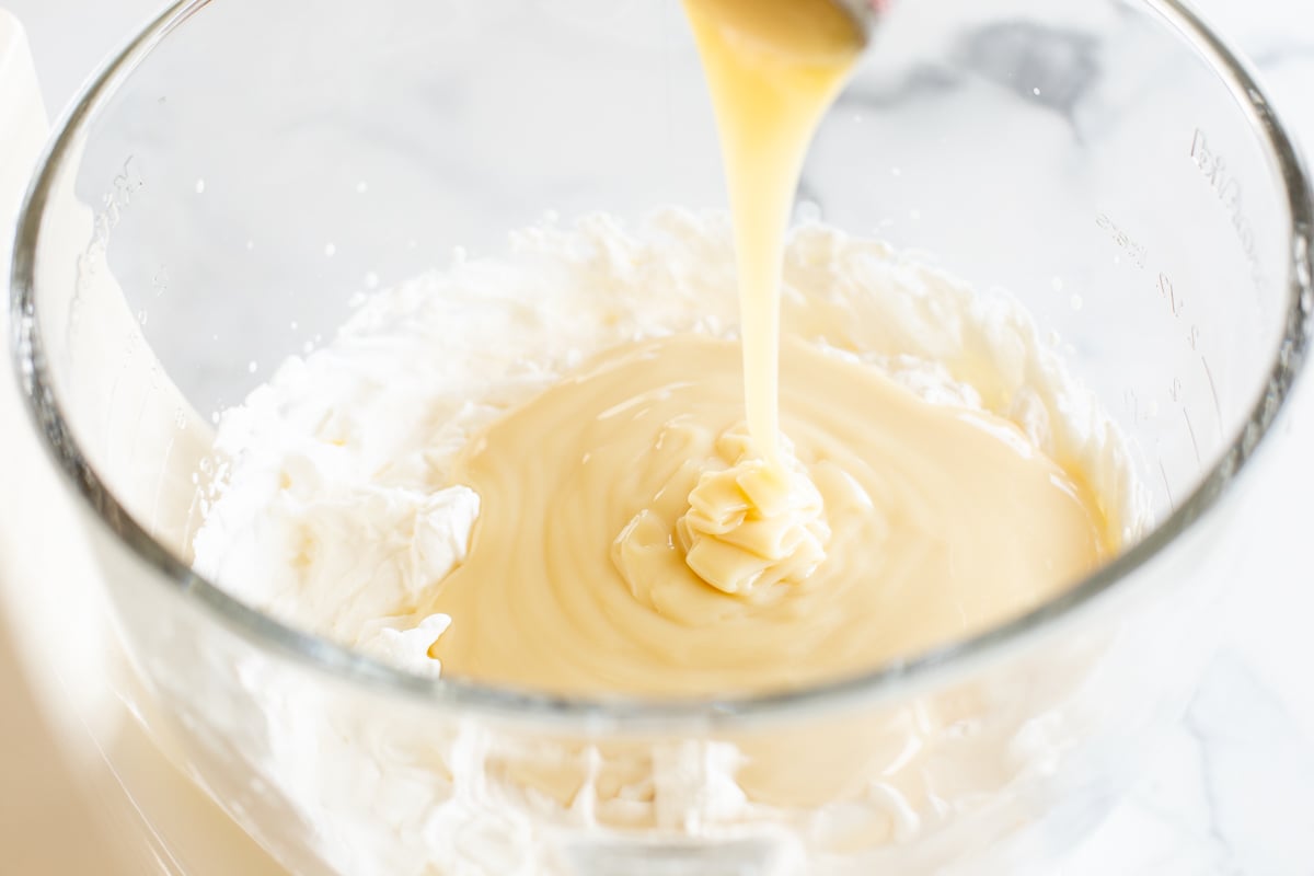 Cake batter ice cream in a glass bowl of a stand mixer.