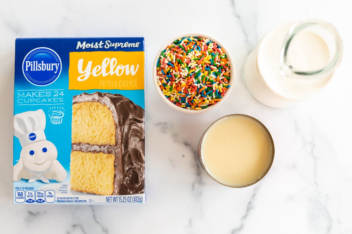 ingredients for no churn cake batter ice cream laid out on a marble countertop