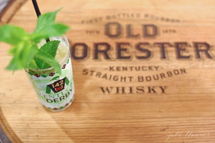 A mint julep on top of a whisky barrel