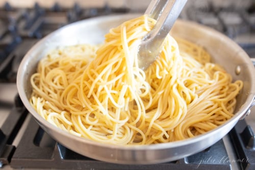 Cacio e pepe in a stainless steel skillet on a stovetop.