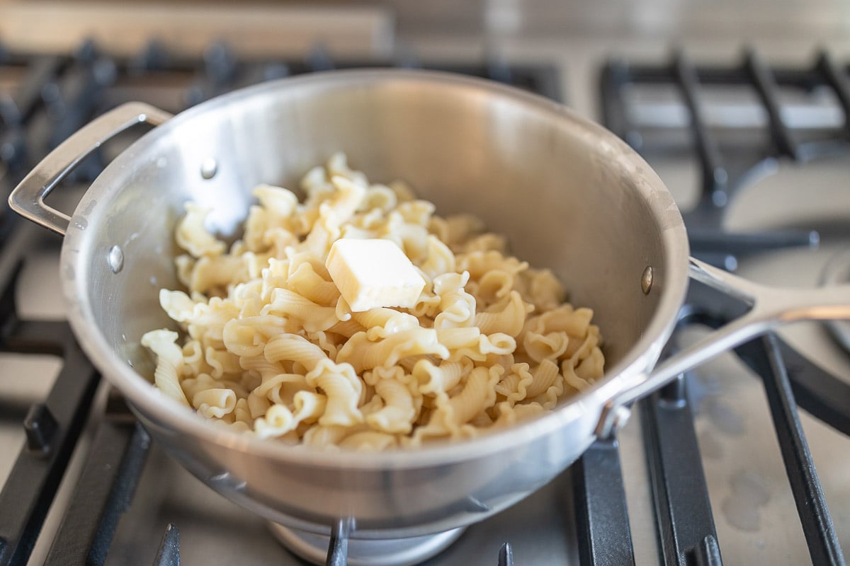 noodles in pot with butter melting on top