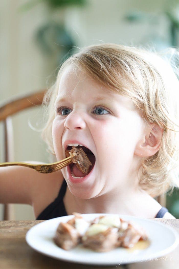 A girl eating a chocolate protein pancake with a fork