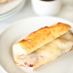 French dip sandwich with provolone cheese on white plate