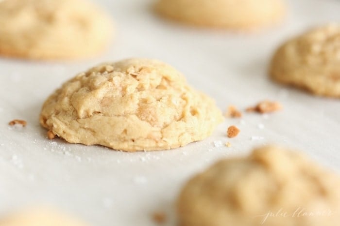 Freshly baked oatmeal brickle cookies on parchment paper