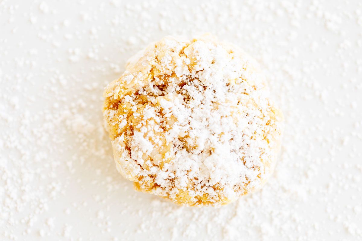 pumpkin gooey butter cookies topped with powdered sugar, laid out on a marble countertop