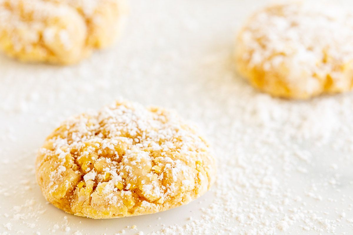 pumpkin gooey butter cookies topped with powdered sugar, laid out on a marble countertop