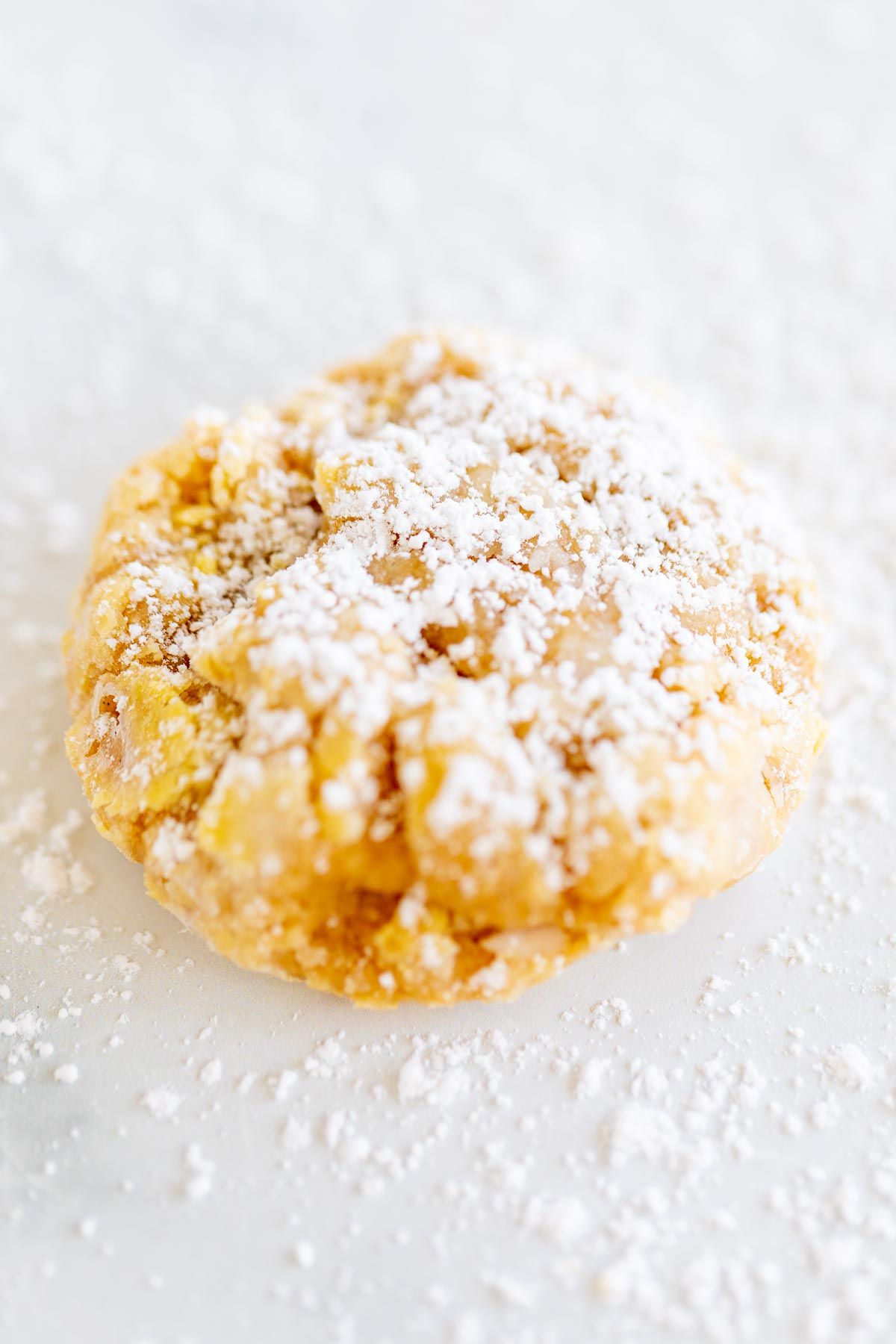 pumpkin gooey butter cookies topped with powdered sugar, laid out on a marble countertop