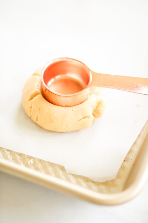 A sugar cookie with a measuring spoon on top.